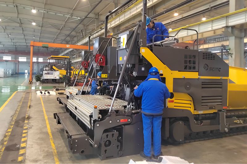1、工人們抓緊時間總裝即將出口的瀝青混凝土攤鋪機.jpg
